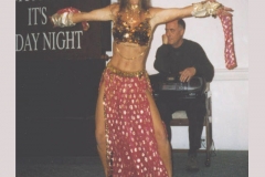 Charlotte Laws belly dancing in outfit she made. Charles behind her